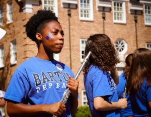 A young flautist stands ready to perform at a sporting event as part of Barton College's Pep Band 